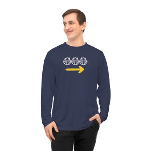 May include: Navy blue long-sleeve shirt with a white graphic of three scallop shells above a yellow arrow pointing right. The shirt is made of a soft, comfortable material.