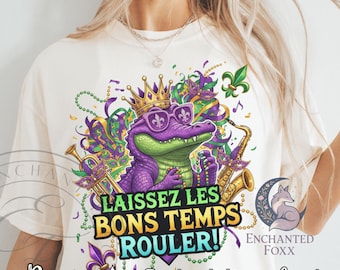 May include: Cream-colored t-shirt featuring a purple alligator wearing sunglasses and a crown, playing a saxophone. The design includes the text "LAISSEZ LES BONS TEMPS ROULER!" and musical notes, with the words "Pngs" and "Instant Download" at the bottom.