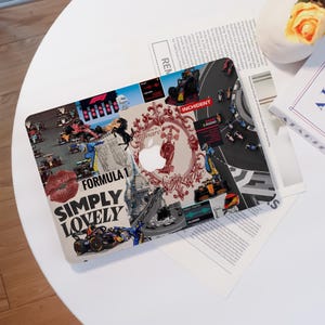 May include: A laptop skin featuring a collage of Formula 1 imagery. The design includes race cars, the text "Formula 1 Simply Lovely", a red lip graphic, and a decorative frame with the Apple logo cutout. The skin is on a white surface.