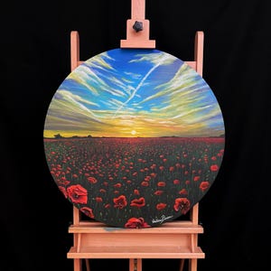 May include: A circular painting on canvas depicting a field of red poppies in bloom at sunset. The sky is a vibrant blue with streaks of white clouds. The sun is setting in the distance, casting a warm glow over the scene.