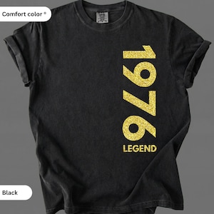 May include: Black t-shirt with the year "1976" in gold glitter lettering. The word "LEGEND" is below the year. The shirt is a Comfort Colors brand.