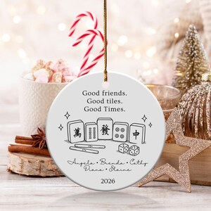 Round ceramic ornament with Mahjong tiles, dice, names, and "Good friends. Good tiles. Good Times. 2026".