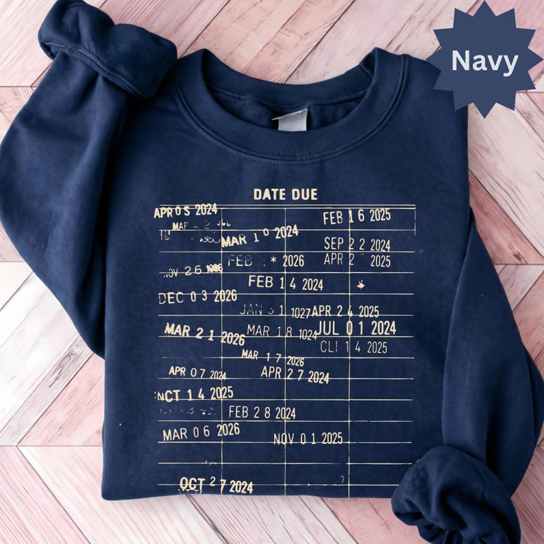 May include: Navy blue sweatshirt with a white graphic resembling a calendar or schedule, featuring dates and the words "DATE DUE." The dates span from 2024 to 2026. The word "Navy" is in a starburst shape.
