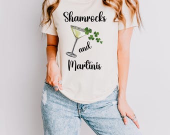 May include: A white t-shirt with the text "Shamrocks and Martinis" printed on it. A green shamrock and a martini glass are also printed on the shirt.