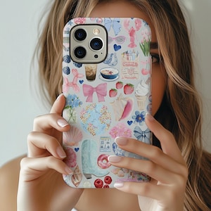 May include: A phone case with a light gray background and a colorful pattern of bows, flowers, food, and other decorative elements. The case features a variety of pastel colors, including pink, blue, and white. The case is designed to fit a smartphone.