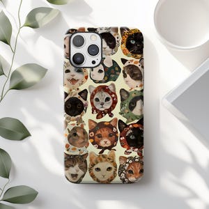 May include: A phone case featuring a repeating pattern of cat faces wearing various hats and hoods. The cats are depicted in a variety of colors, including black, white, orange, and gray, against a light yellow background. The case has a camera cutout.