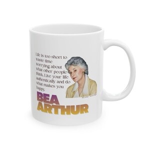 May include: White ceramic mug featuring a portrait of Bea Arthur and the quote "Life is too short to waste time worrying about what other people think." The mug has a curved handle and the text "BEA ARTHUR" in a gradient color.