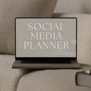 Op de afbeelding: Een laptop met "SOCIAL MEDIA PLANNER" op het scherm staat op een beige bank. De tekst "PLR PRODUCT" staat eronder, met de Instagram-handle "@THE.DIGITAL.MAGIC" onderaan. De scène is in neutrale tinten.