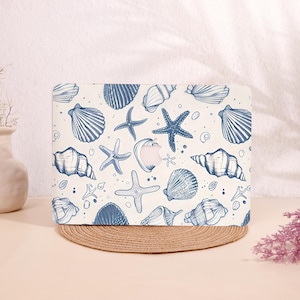 May include: A laptop case featuring a repeating pattern of blue seashells and starfish on a cream background. The design includes various shell shapes and starfish, creating a coastal theme. The case is designed to fit a laptop.