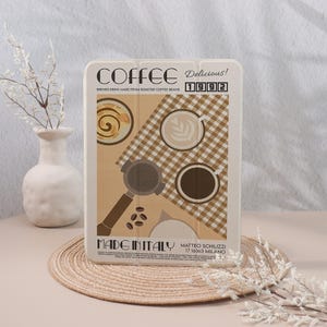 May include: A rectangular coffee-themed design with the word "COFFEE" and the year "1992". The design includes coffee cups, a portafilter, and coffee beans. The text "MADE IN ITALY" is also visible. The design is on a light-colored background.