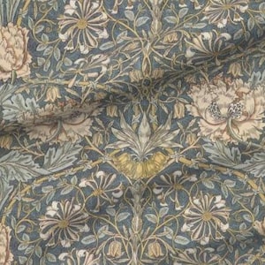 May include: A patterned fabric featuring a repeating floral design in blue, beige, and green hues. The vintage-style pattern showcases stylized flowers and leaves, creating a symmetrical and detailed design.