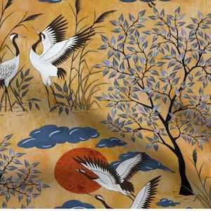 May include: Fabric with a Japanese-inspired design featuring white cranes with black wingtips, flying and standing among tall grass, trees, and dark blue clouds. The background is a warm, golden color with a red sun.