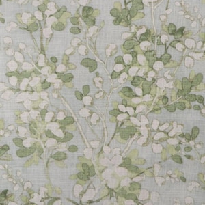 May include: A light blue fabric with a white and green floral pattern. The pattern features small white flowers and green leaves.