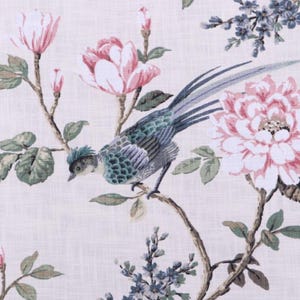 May include: Floral fabric featuring a detailed print of a bird perched on a branch, surrounded by pink and white flowers, green leaves, and blue accents. The design is set against a light beige background.