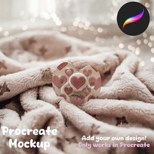 May include: A pink and white pacifier with a heart pattern on a soft, fluffy blanket. The pacifier is designed for use with the Procreate app.