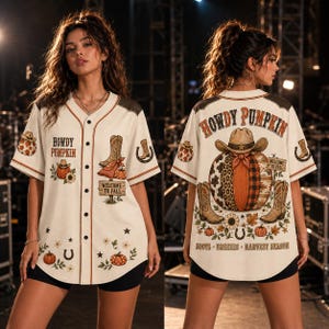 May include: A cream-colored button-down baseball jersey featuring fall-themed graphics including pumpkins, cowboy boots, sunflowers, and horseshoes. The front and back display the text "HOWDY PUMPKIN" and "WELCOME TO FALL" with additional seasonal motifs.