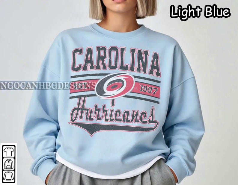 May include: Light blue sweatshirt with a Carolina Hurricanes logo and the text "Carolina Hurricanes 1997".
