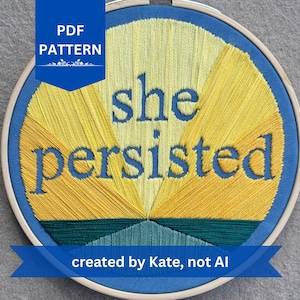 Puede incluir: Un bastidor de bordado con la frase "she persisted" bordada en hilo azul. El diseño presenta hilos amarillos y turquesa en un patrón de rayos de sol. También se incluye el texto "PDF PATTERN" y "created by Kate, not AI".