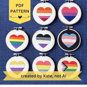 May include: A collection of eight circular embroidery hoops featuring heart-shaped designs with various pride flag color patterns on white and black fabric. The image includes text that reads PDF PATTERN and created by Kate, not AI.