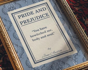 May include: A rectangular gold-toned ornate frame containing a print with a light blue damask background. The central white panel features the text Pride and Prejudice, the quote You have bewitched me, body and soul, and by Jane Austen.