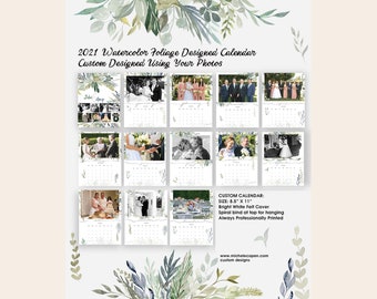 May include: A 2021 watercolor foliage designed calendar with a white felt cover. The calendar is 8.5 inches by 11 inches and has a spiral bind at the top for hanging. The calendar is professionally printed and features a custom design using your photos.