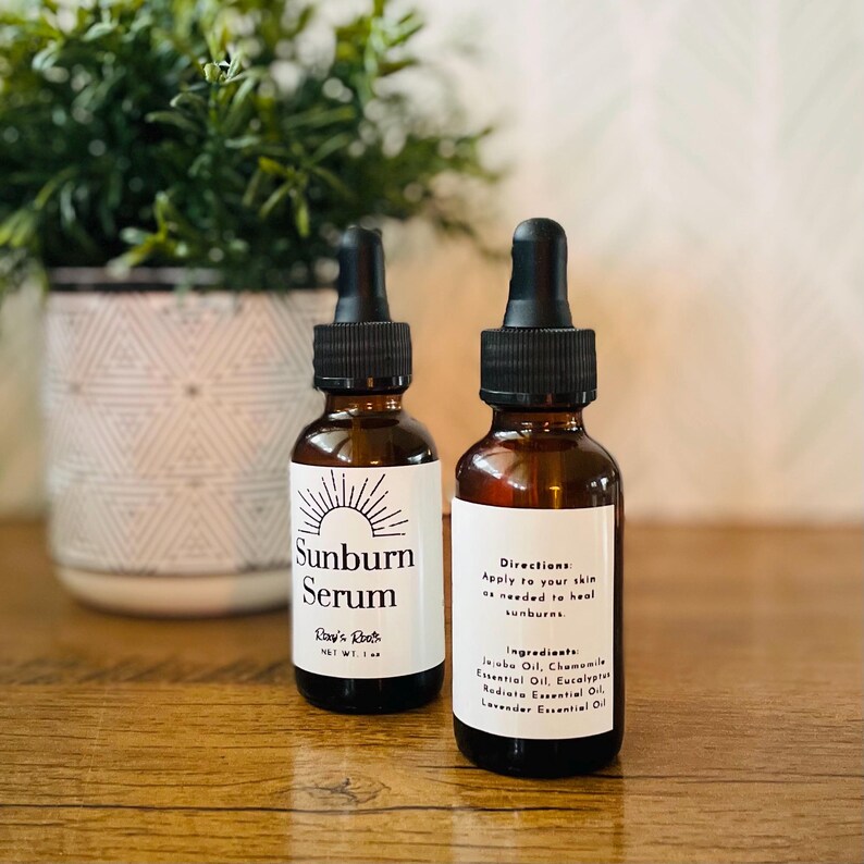 May include: Two amber glass bottles of Sunburn Serum with black droppers. The labels include the text "Sunburn Serum" and "Ray's Roots." One bottle lists directions and ingredients, including Jojoba Oil and Lavender Essential Oil.