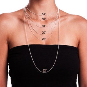 May include: A silver chain necklace with different lengths marked in inches, from 14 inches to 32 inches.