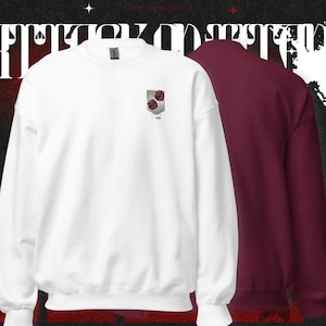May include: White and burgundy crewneck sweatshirts. The white sweatshirt features a small emblem with two red roses. The burgundy sweatshirt is displayed behind the white one. The background is black with white text and star accents.