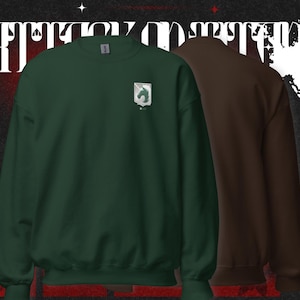 Könnte beinhalten: Zwei Sweatshirts, eines in Dunkelgrün und eines in Braun, werden vor einem dunklen Hintergrund mit weißem Text gezeigt. Das grüne Sweatshirt hat ein kleines Emblem auf der Brust. Das braune Sweatshirt befindet sich rechts. Der Hintergrund hat japanischen Text.