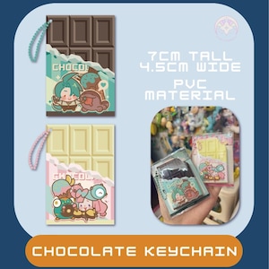 Puede incluir: Llavero de chocolate, 7 cm de alto y 4,5 cm de ancho, hecho de material de PVC. El llavero presenta un diseño de tableta de chocolate con personajes de dibujos animados y la palabra "CHOCO". El llavero es marrón y blanco.