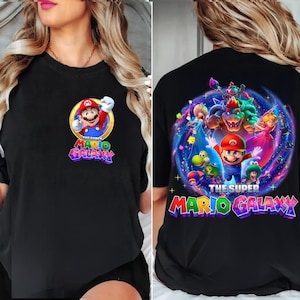 Pode incluir: Camiseta preta com um gr&aacute;fico colorido de Mario do videogame "The Super Mario Galaxy". A frente da camiseta tem um design circular com Mario. A parte de tr&aacute;s da camiseta tem um gr&aacute;fico maior com v&aacute;rios personagens.
