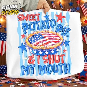 May include: A white t-shirt featuring a graphic of a pie with a crust patterned like the American flag. The text reads SWEET POTATO PIE & I SHUT MY MOUTH in red and blue letters, surrounded by blue and red stars and light blue vertical stripes.