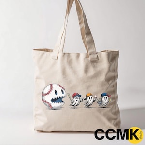 May include: Beige tote bag featuring a baseball with a ghost face and three ghost figures wearing baseball caps. The bag has long handles and the text "CCMK studio" in the bottom right corner.
