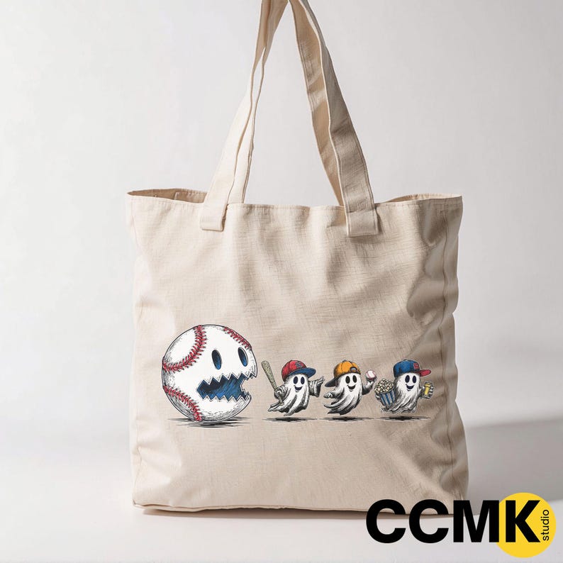 May include: Beige tote bag featuring a baseball with a ghost face and three ghost figures wearing baseball caps. The bag has long handles and the text "CCMK studio" in the bottom right corner.
