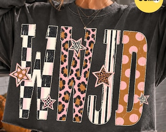 May include: A charcoal gray cropped sweatshirt featuring the letters WWJD in a large graphic print. The letters are filled with various patterns including black and white checkers, pink leopard print, black and white stripes, and brown polka dots.