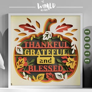 May include: A layered paper craft design of a pumpkin with fall leaves. The pumpkin has the words "Thankful Grateful and Blessed" written on it.
