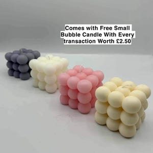 May include: Four square bubble candles in different colours: grey, white, pink, and cream.  Comes with Free Small Bubble Candle With Every transaction Worth £2.50