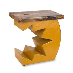 K&ouml;nnte beinhalten: Ein gelber Holz-Beistelltisch mit einem einzigartigen, geometrischen Design. Der Tisch hat eine geschwungene, abgestufte Basis und eine rechteckige Platte aus recyceltem Holz.
