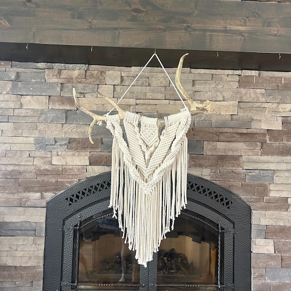White macrame wall hanging on antler