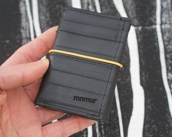 Trifold wallet with elastic band closure, zipper pocket for coins, hold cash and cards, compact and functional, upcycled product.