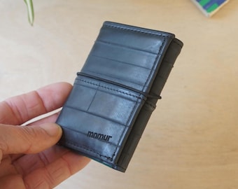 Trifold wallet with elastic band closure, zipper pocket for coins, hold cash and cards, compact and functional, upcycled product.