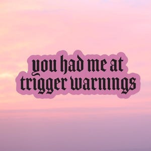 Puede incluir: Un fondo degradado rosa y morado con una pegatina negra que dice "you had me at trigger warnings" en una fuente gótica.