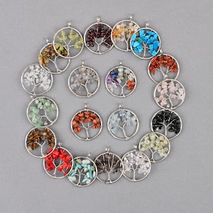 May include: Assortment of 18 silver wire tree of life pendants with different colored gemstone chips. Each pendant features a silver wire tree with a circular frame and is filled with various colored gemstone chips.
