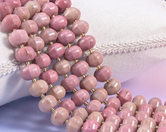 May include: A multi-strand necklace featuring numerous faceted, round, dusty pink rhodonite beads. The beads are strung on thin, metallic gold-toned wire, creating a layered effect with a consistent, polished texture throughout the entire piece.
