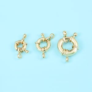 Puede incluir: Una taza de cerámica blanca con un asa negra y el texto "But First, Coffee" en un estilo manuscrito. La taza está sobre una superficie blanca. La taza mide aproximadamente 10 cm de alto.