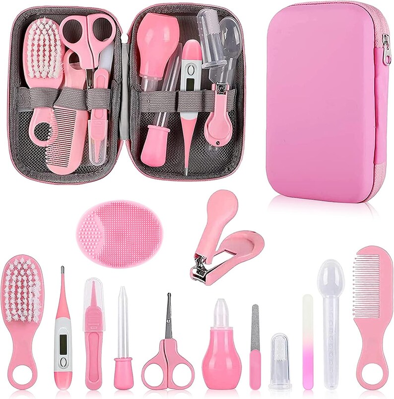 May include: A pink baby grooming kit with a variety of tools, including a brush, comb, scissors, nail clippers, and a thermometer. The kit is in a zippered case and includes a pink silicone face scrubber.