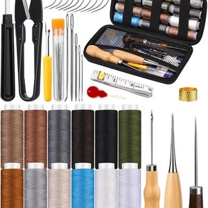 May include: A leather sewing kit with a variety of tools, including needles, thread, awls, a thimble, scissors, and a tape measure. The kit comes in a black carrying case with a zipper closure. The thread spools are in a variety of colors, including brown, gray, black, and green.