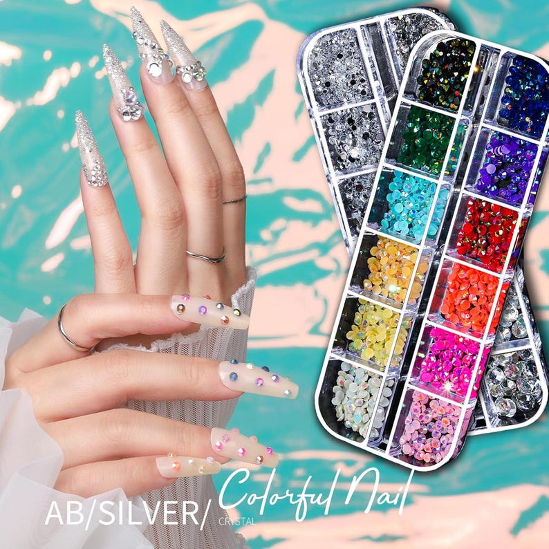 Op de afbeelding: Afbeelding van twee handen met lange, versierde nagels. De nagels zijn versierd met zilveren glitter en strass-steentjes. Twee bakjes met kleurrijke nail art strass-steentjes staan op de achtergrond. De tekst "AB/SILVER/ Colorful Nail CRYSTAL" staat onderaan.