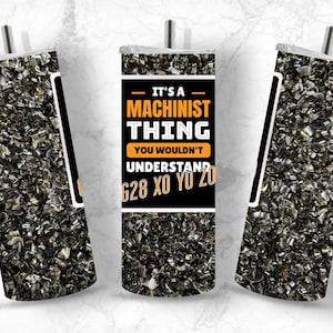 Puede incluir: Un vaso negro y naranja con un diseño de virutas de metal y el texto "It's a Machinist Thing You Wouldn't Understand G28 XO YO ZO".