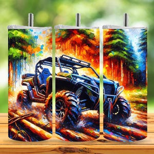 May include: A colorful tumbler featuring an off-road vehicle in a forest setting. The design showcases a vibrant painting style with a blue, yellow, and black ATV, set against a backdrop of trees in shades of red, orange, and green.